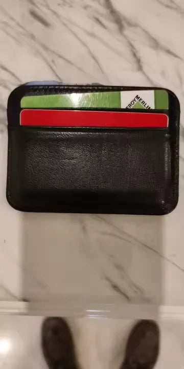 Tarjetero negro con tarjetas sobre una superficie de mármol